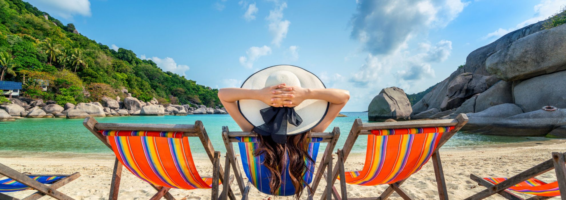 Woman with hat sitting on chairs beach in beautiful tropical bea Woman with hat sitting on chairs beach in beautiful tropical beach. Woman relaxing on a tropical beach at Koh Nangyuan island.
